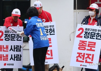 [포토] 상대후보 선거운동원과 인사 나누는 민주당 후보